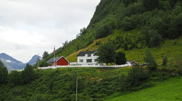 Bilde av hvitt hovedhus i naturlandskap