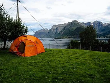 Telt på gressplen ved fjord